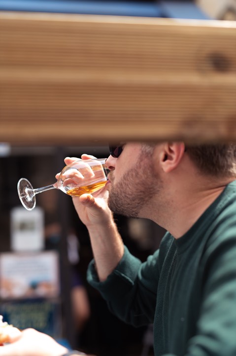 Un homme qui boit un verre sur la terrasse d’un restaurant pour Les Arlots à Paris, France.