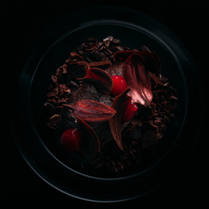 Dessert rouge dressé dans une assiette sombre pour Oxygen’s Dining Room by Nicolas Isnard à Chiang Mai, Thaïlande.