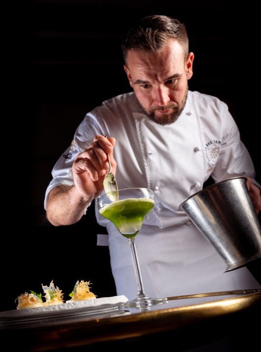 Le chef Kévin Stroh apportant la touche finale à un plat pour Auberge des Templiers en France.