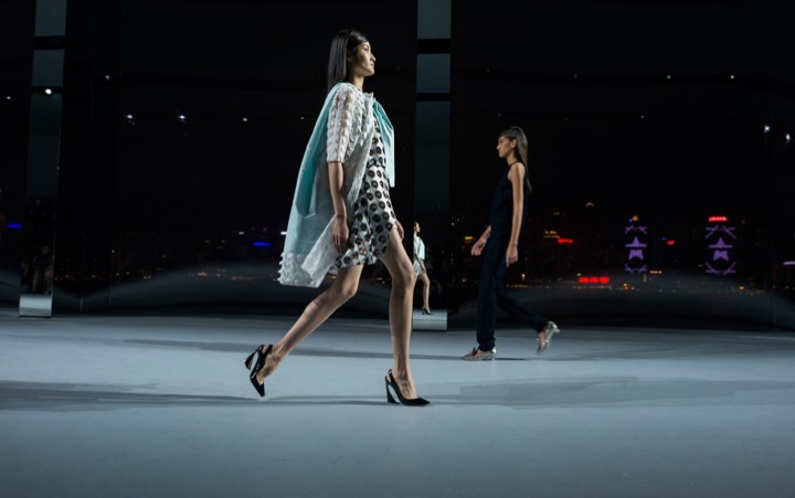 Mannequin marchant sur un podium de nuit pour Bureau Betak pour Dior à Hong Kong.