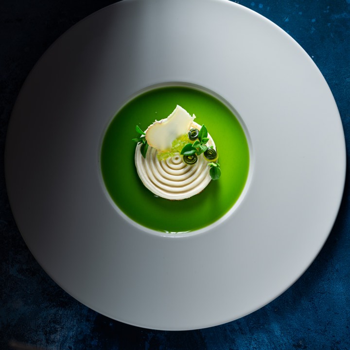 Velouté vert dressé avec une crème pour Auberge des Templiers à Boismorand, France.