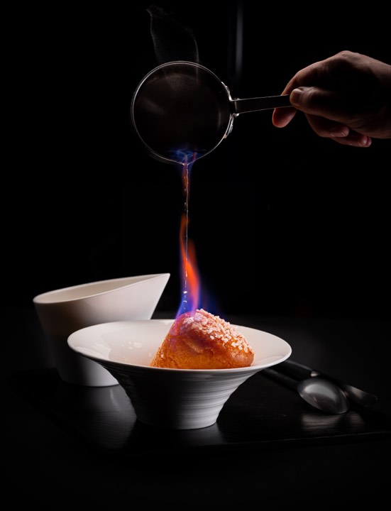 Baba au rhum dressé dans une assiette pour Mr & Mrs Bund by Paul Pairet à Shanghai, Chine.