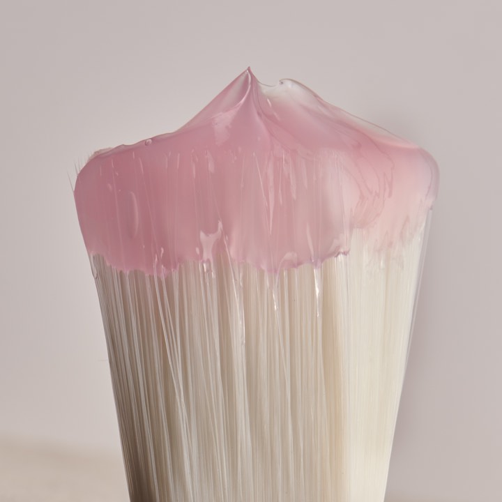 Pinceau recouvert d’une matière rose pour Evidens à Paris, France.