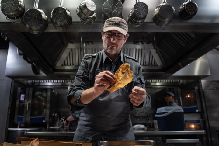 Paul Pairet préparant un coquillage en cuisine pour Ultraviolet by Paul Pairet à Shanghai, Chine.
