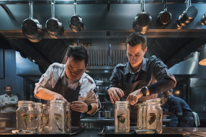 Deux chefs préparant des bocaux en cuisine pour Ultraviolet by Paul Pairet à Shanghai, Chine.
