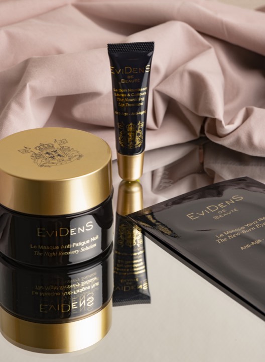 Produits de soin Evidens disposés sur un textile rose pour Evidens à Paris, France.