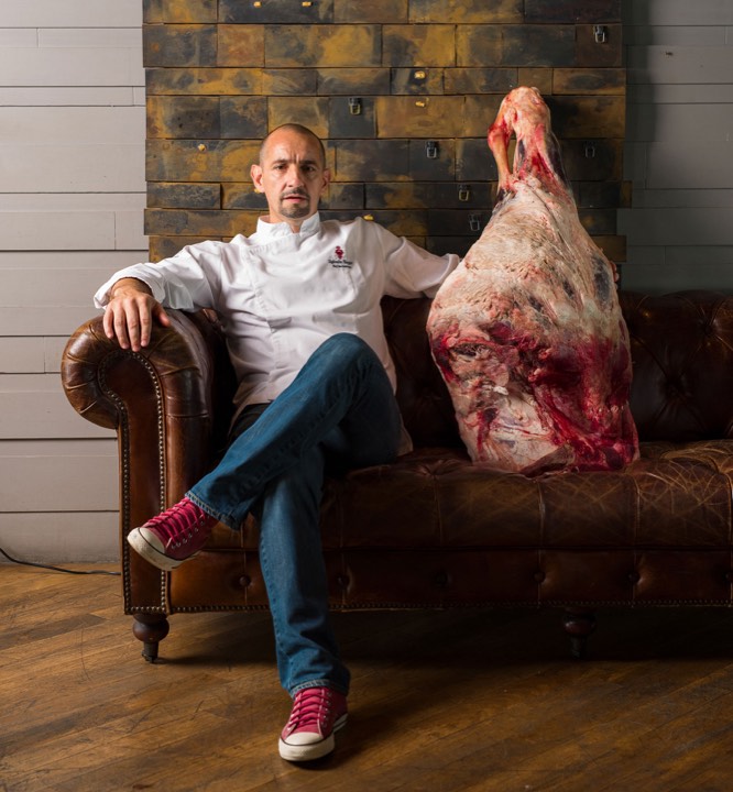 Chef assis à côté d’une pièce de viande pour Scarlett Bangkok à Bangkok, Thaïlande.