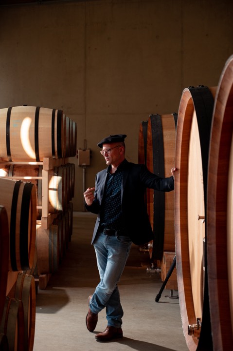 Portrait d'un vigneron au milieu des fûts en chêne pour Monastère de Saint-Mont à Saint-Mont, France.