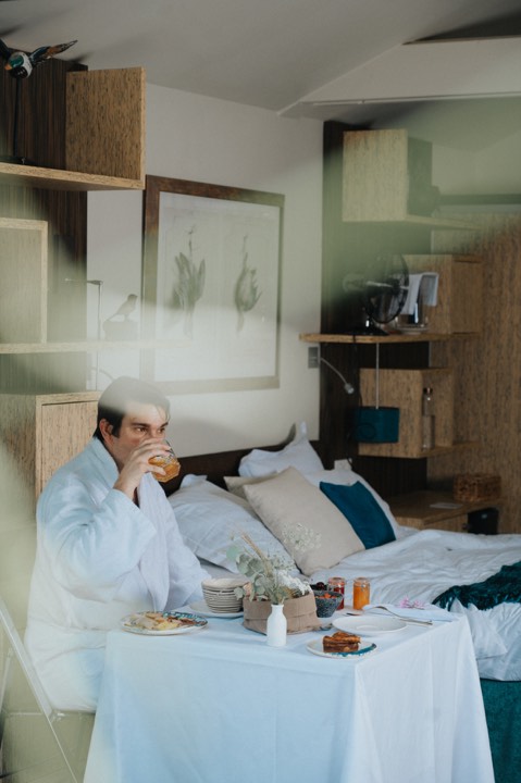 Homme prenant son petit-déjeuner dans une chambre d’hôtel pour La Mare aux Oiseaux à Saint-Joachim, France.