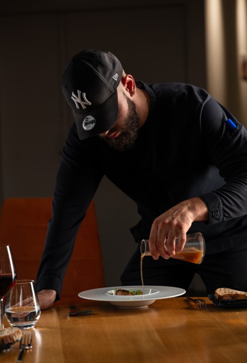 Le chef Adrien Cresci qui sert la sauce sur un plat gastronomique pour Ciel à Table à Toulouse, France.