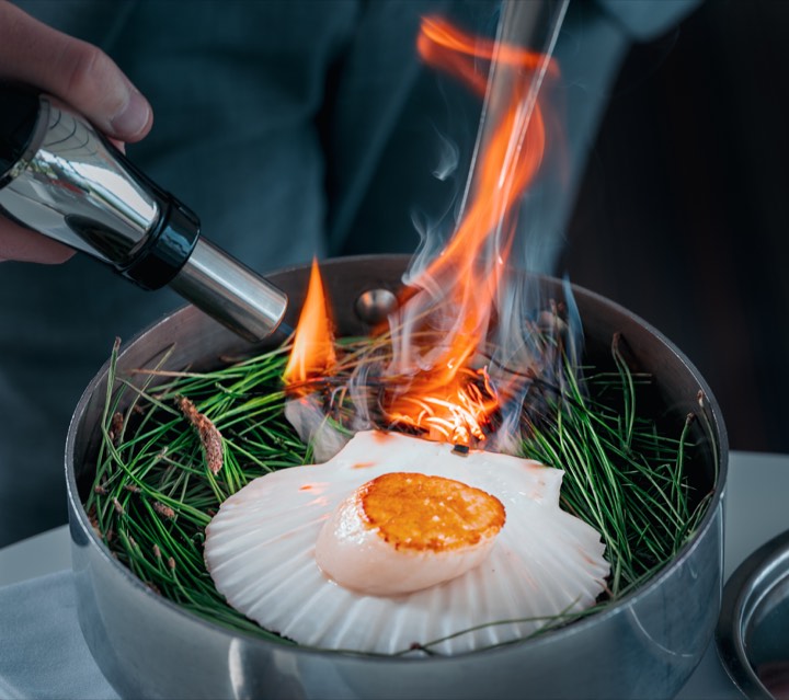Coquille Saint-Jacques flambée au chalumeau pour Saint James à Bouliac / Bordeaux, France.