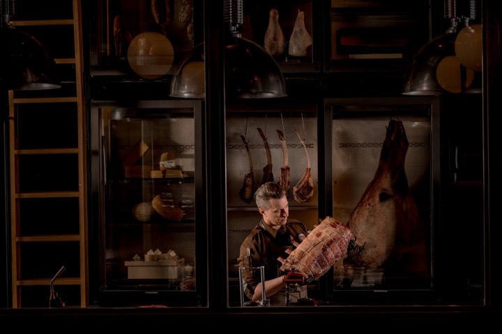 Un chef examine des côtes de bœuf pour Moutarde à Singapour.