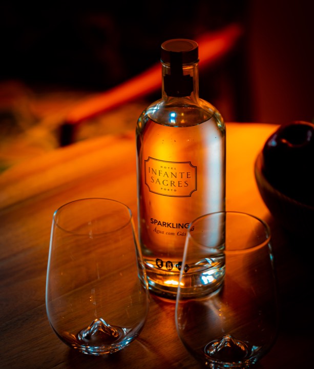 Bouteille de gin et verre sur une table pour Hôtel Infante Sagres à Porto, Portugal.
