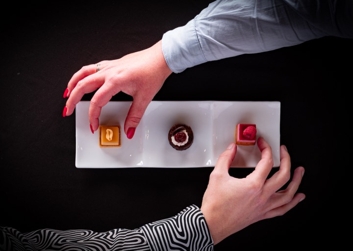 Trois desserts sur une assiette rectangulaire, deux mains s’apprêtant à les prendre pour Miniature Original Food en France.