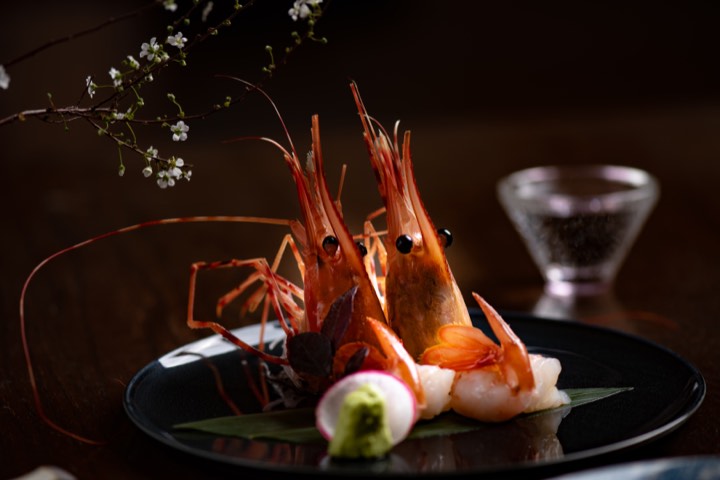 Langoustines dressées dans une assiette noire pour Shinpaku à Shanghai, Chine.