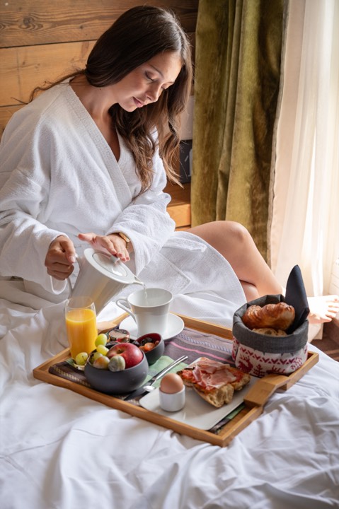 Femme prenant son petit-déjeuner au lit pour Grand Tétras à Font-Romeu, France.