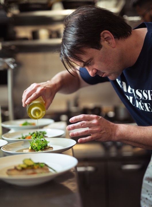 Le chef Thomas Brachet qui termine de monter une assiette pour Les Arlots à Paris, France.